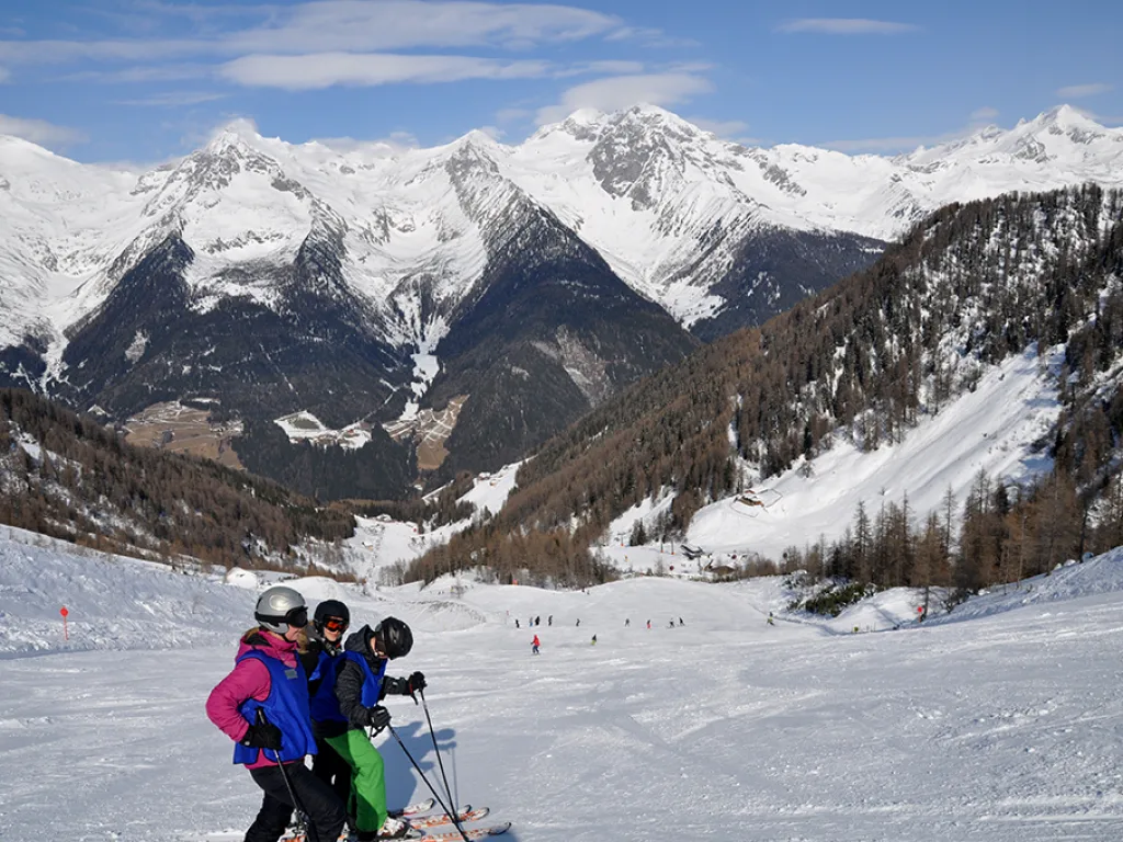 Blick über die Piste auf die schneebedeckte Bergkette.